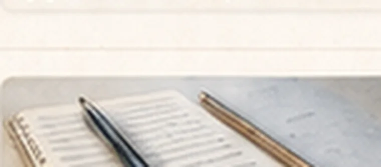 Un carnet ouvert, un stylo et un crayon posés dessus